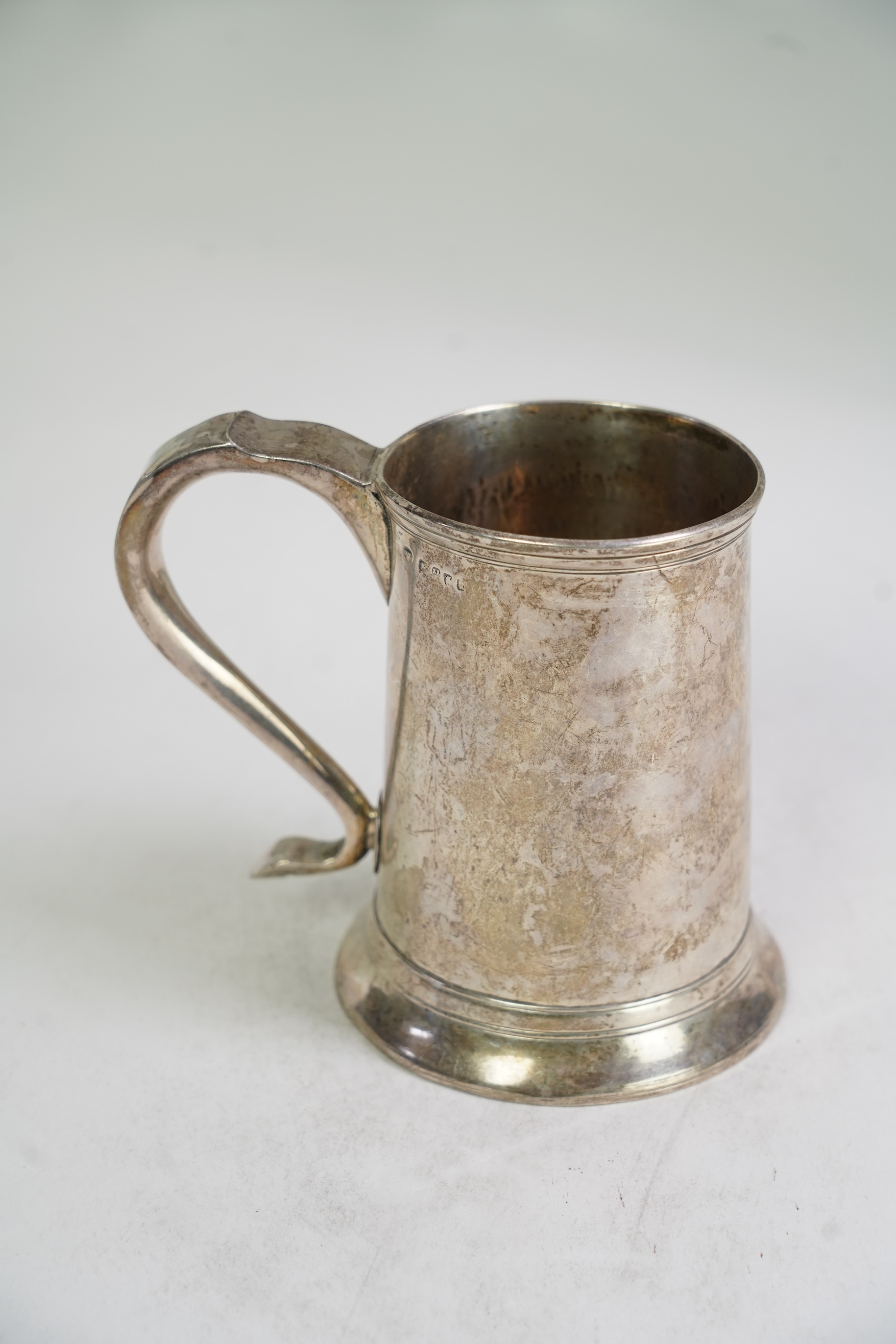 A George III provincial silver mug, by Dorothy Langlands, of plain design, with scroll handle, no date latter, Newcastle, circa 1810, height 13.1cm, 10.6oz, (a.f.).